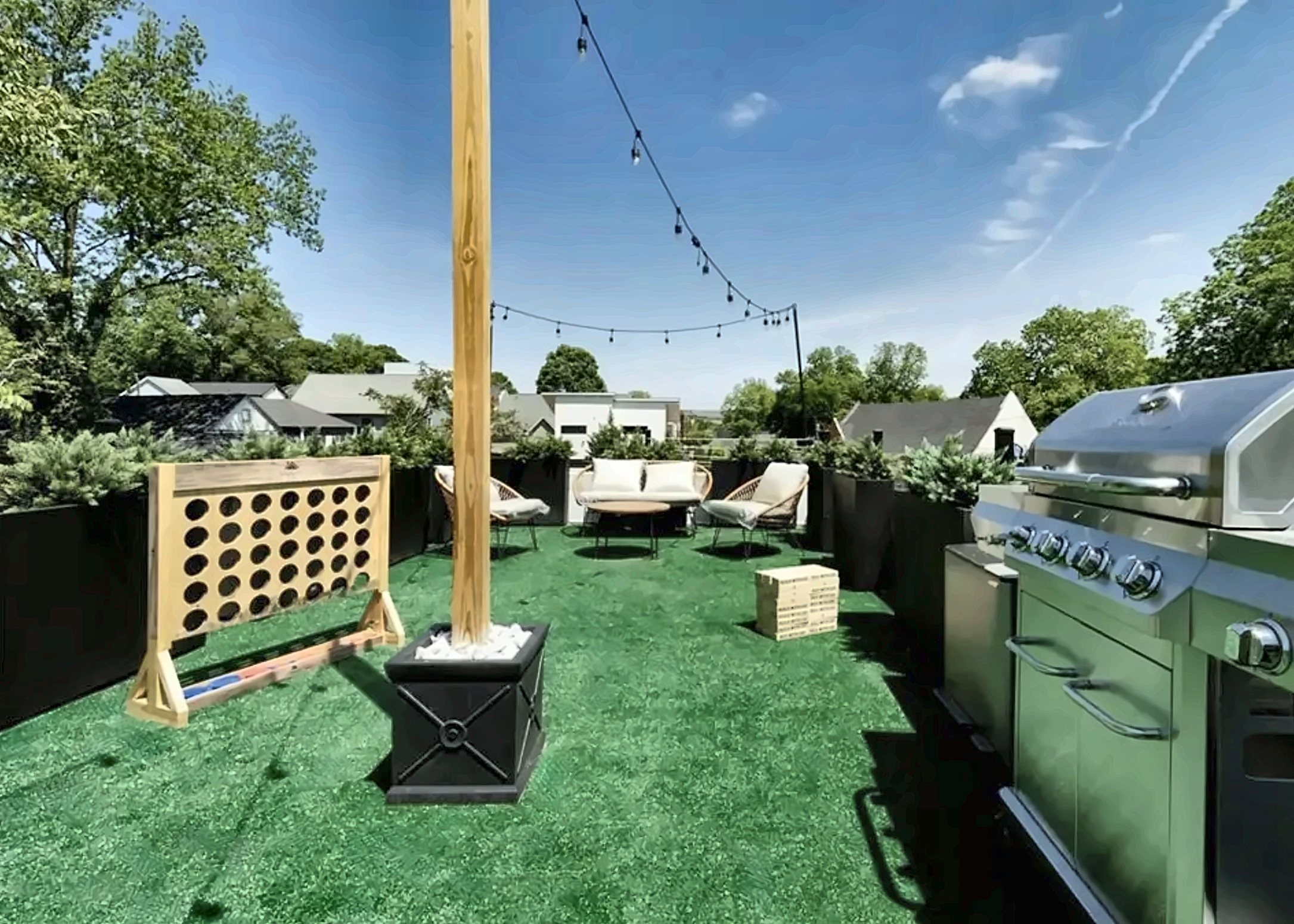 Rooftop deck with grill station, seating area and city views