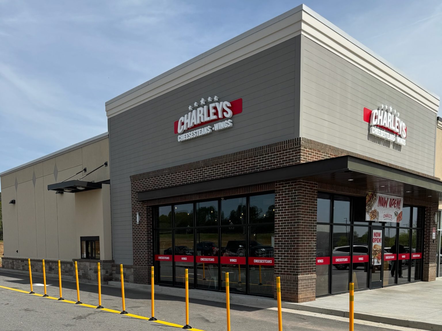 Finished Charleys Cheesesteaks restaurant exterior with brick storefront and drive-thru lane