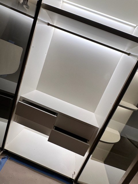 Lit hanging section above built-in drawers