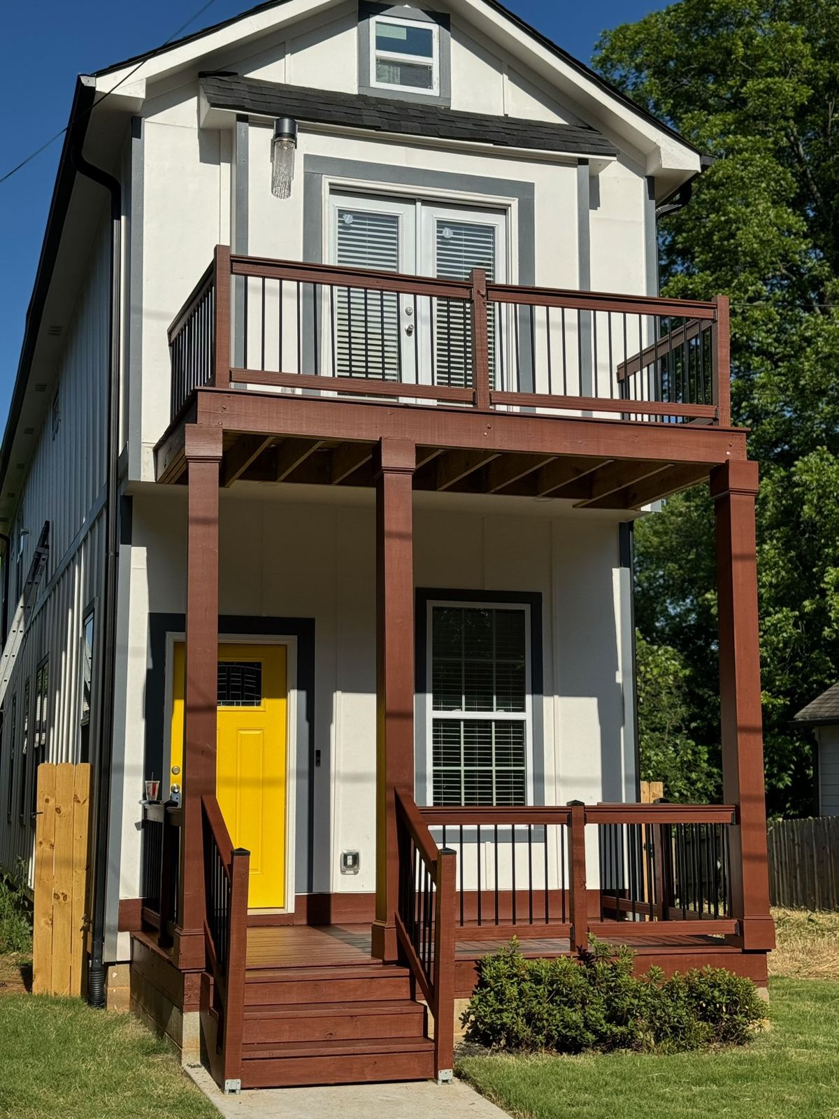 Two-story home with a yellow front door and double front porch